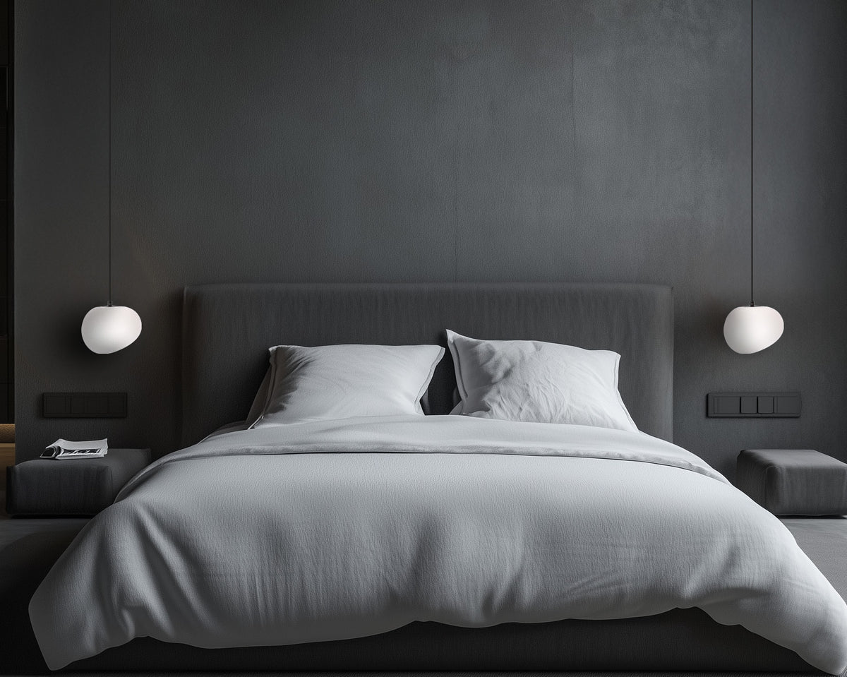 Ambiance chambre sombre avec deux suspensions blanches de chaque côté du lit