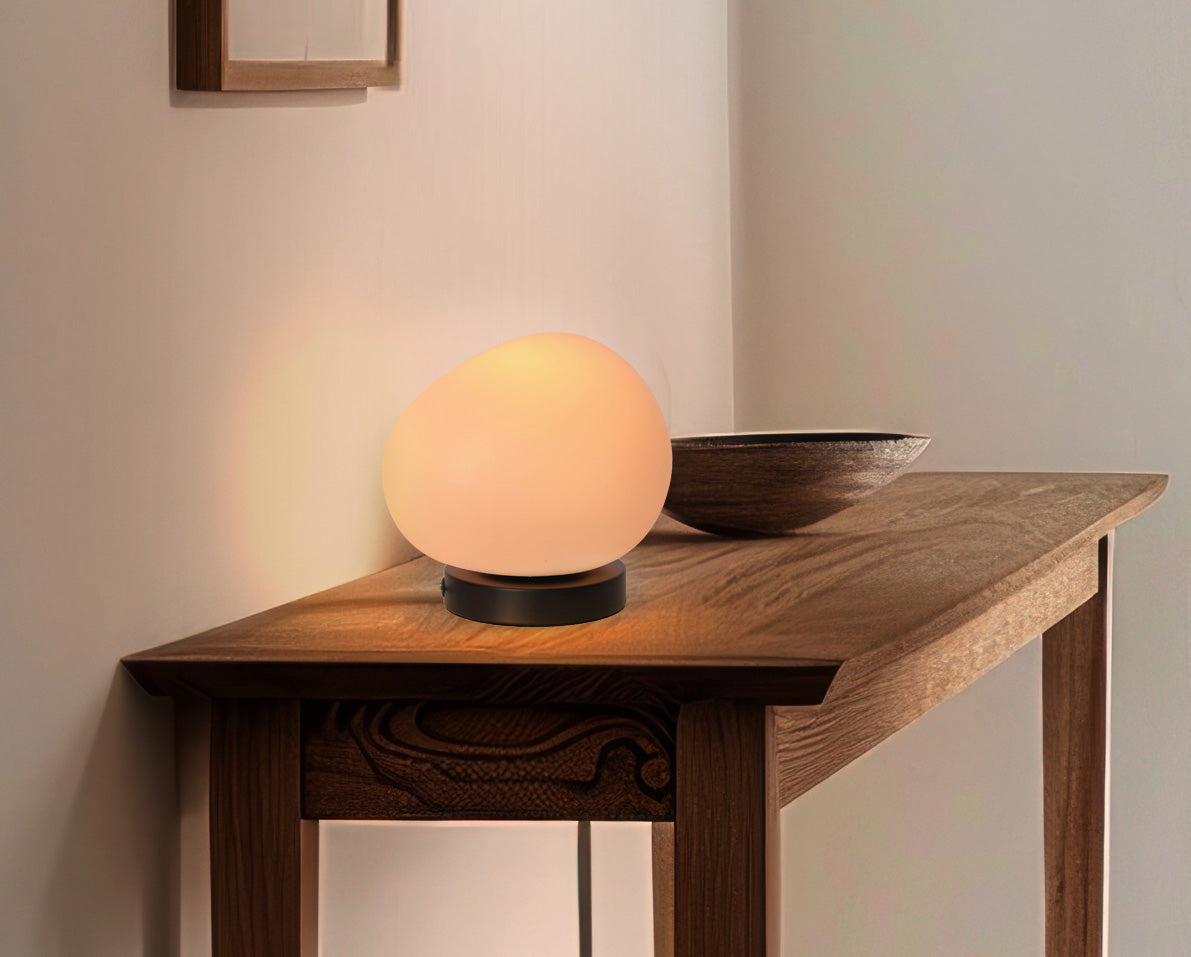 Lampe allumée sur table en bois, diffusant une lumière chaude dans la pièce