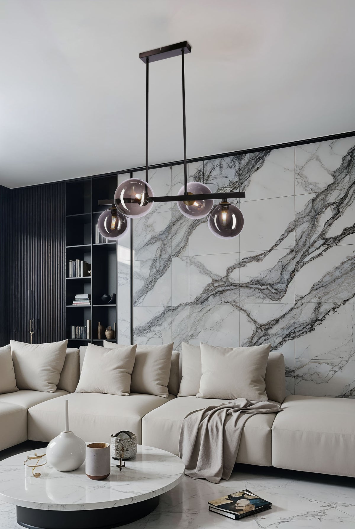 Suspension allumée dans un salon moderne, devant un mur en marbre et un canapé beige.