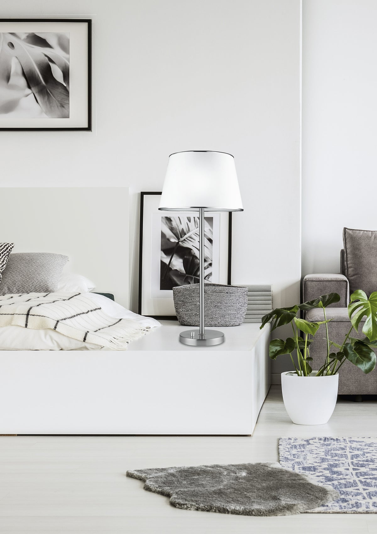 Mise en ambiance chambre claire, lampe posée sur un meuble bas près du lit