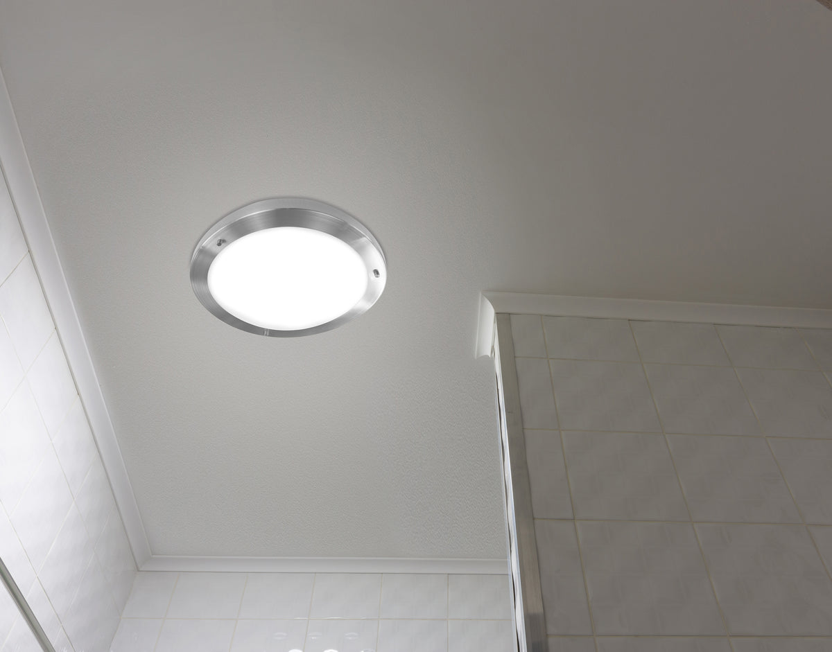 Plafonnier allumé fixé au plafond d'une salle de bains carrelée de blanc