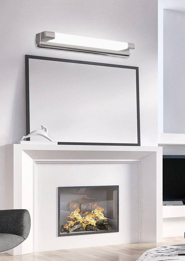 Mise en ambiance : applique allumée au-dessus d'un miroir noir dans un salon clair.