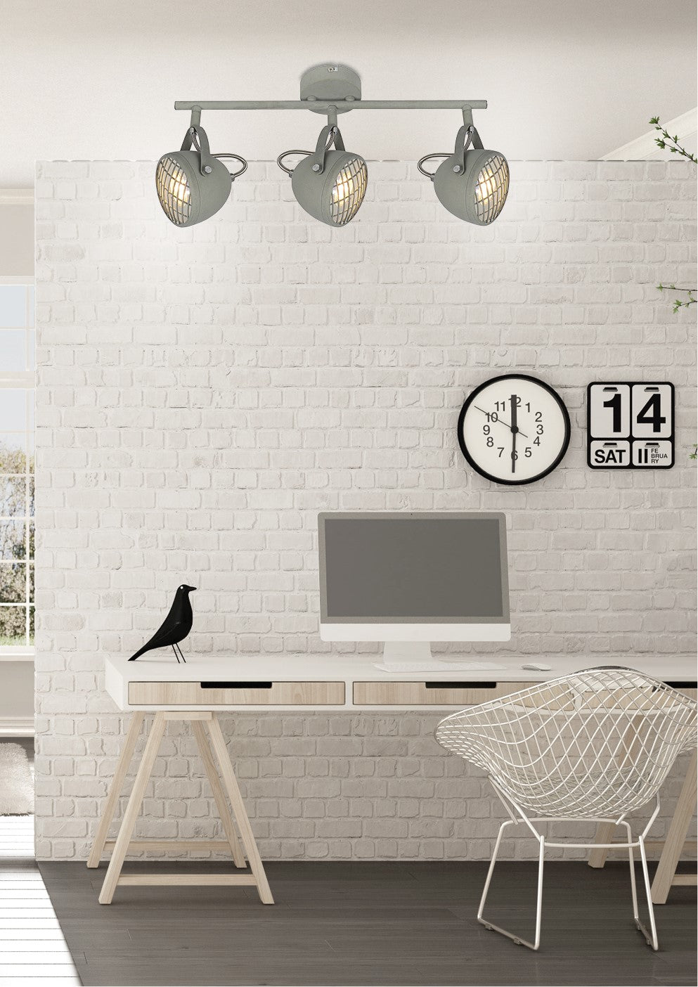 Plafonnier gris installé au-dessus d'un bureau blanc devant un mur de briques.