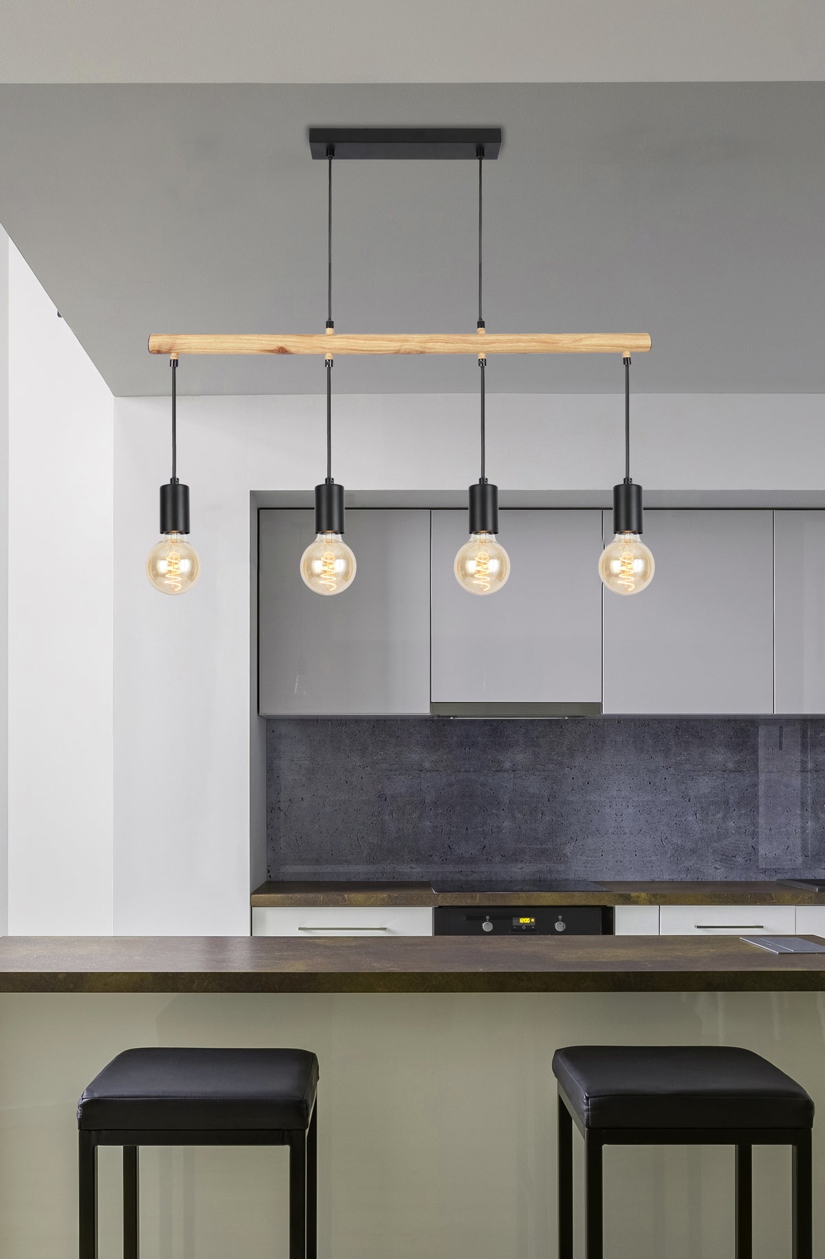 Suspension installée au-dessus d'un îlot de cuisine gris avec deux tabourets noirs