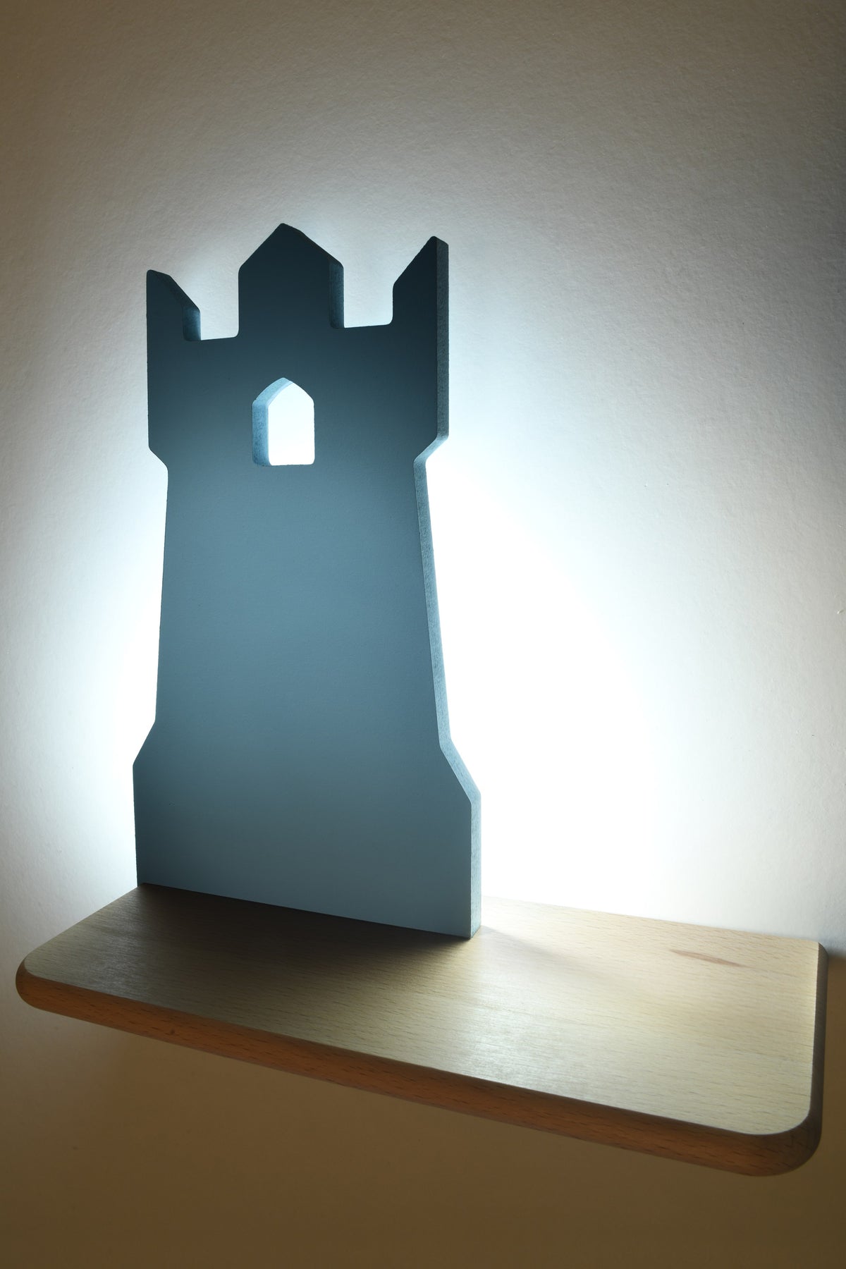 Mise en ambiance chaleureuse, applique bleue allumée projetant un halo lumineux sur le mur