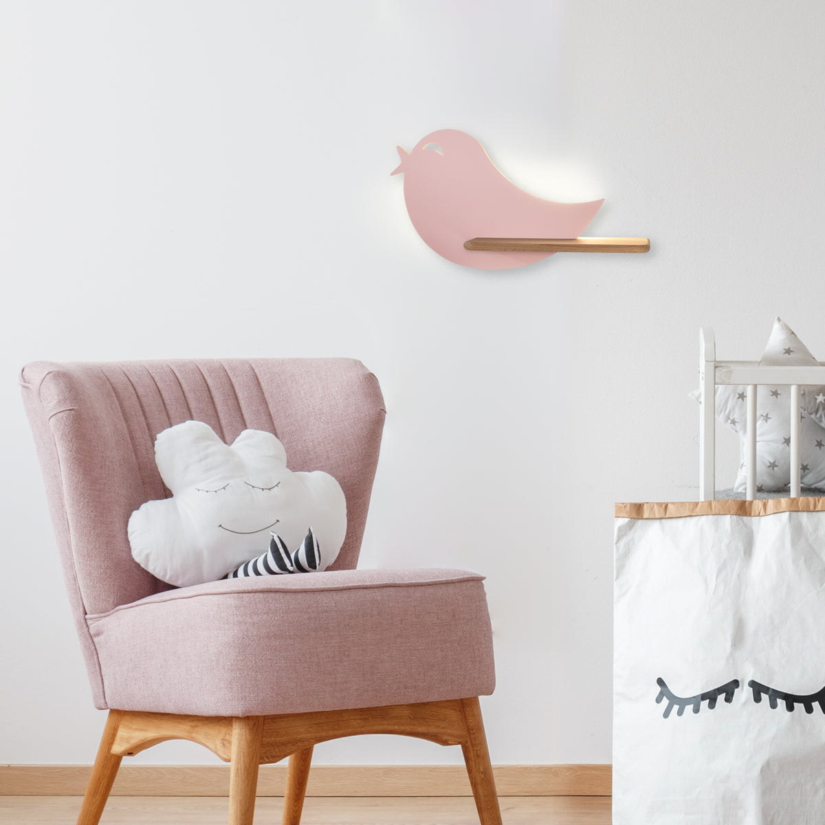 Vue large de la chambre montrant l'applique oiseau fixée au mur blanc au-dessus du fauteuil