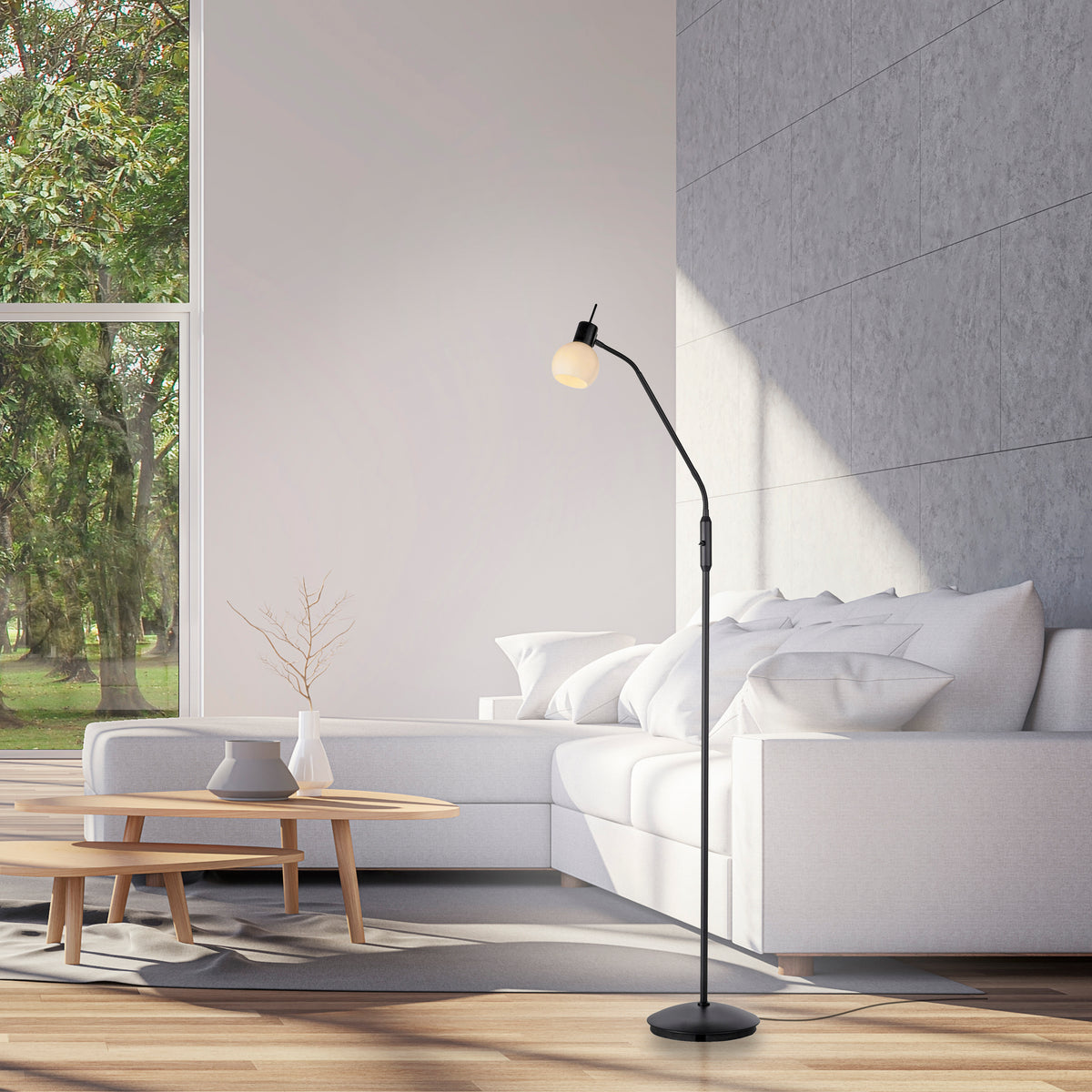 Mise en ambiance dans un salon, lampadaire allumé près d'un canapé et table basse.