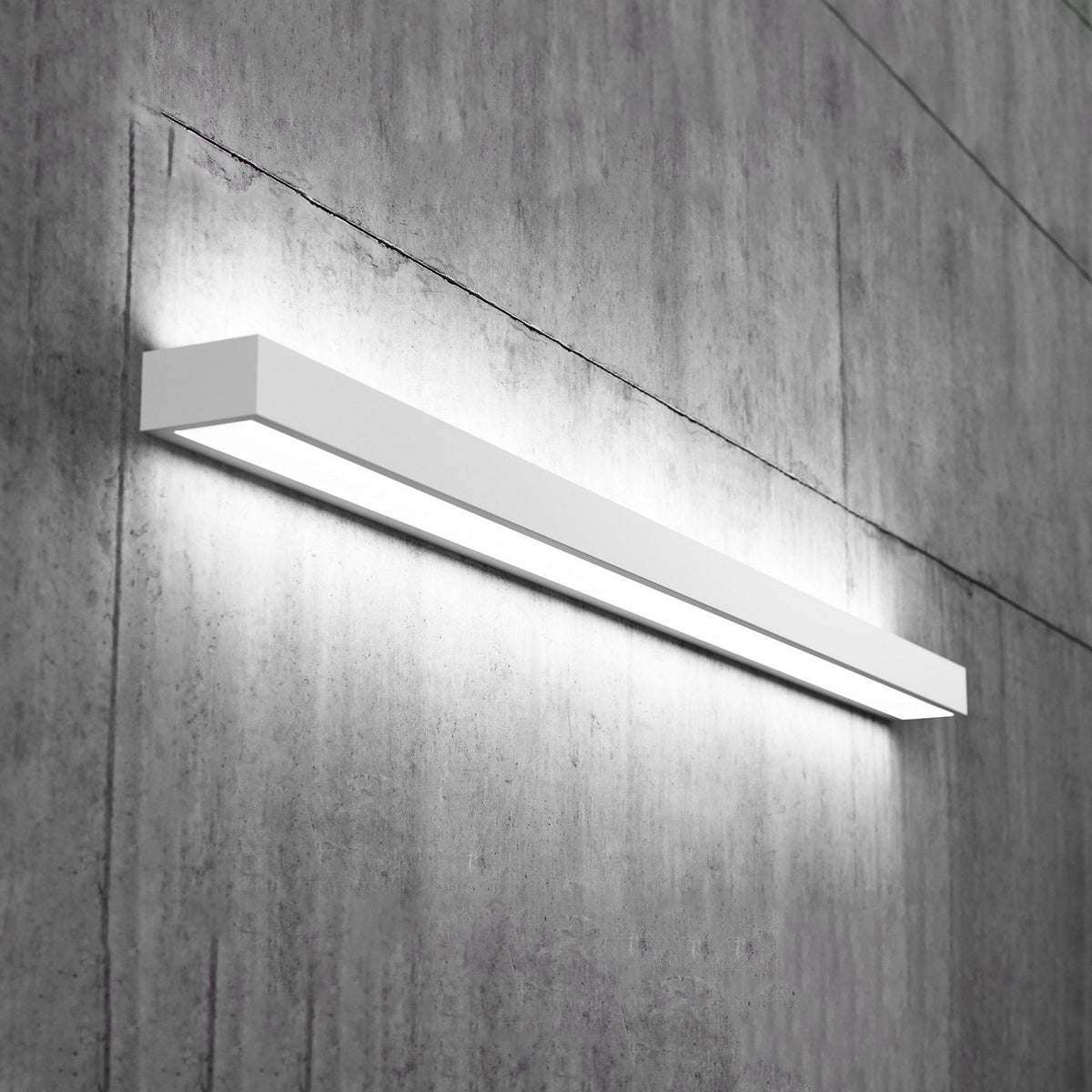 Applique murale LED blanche allumée, fixée sur un mur en béton texturé.