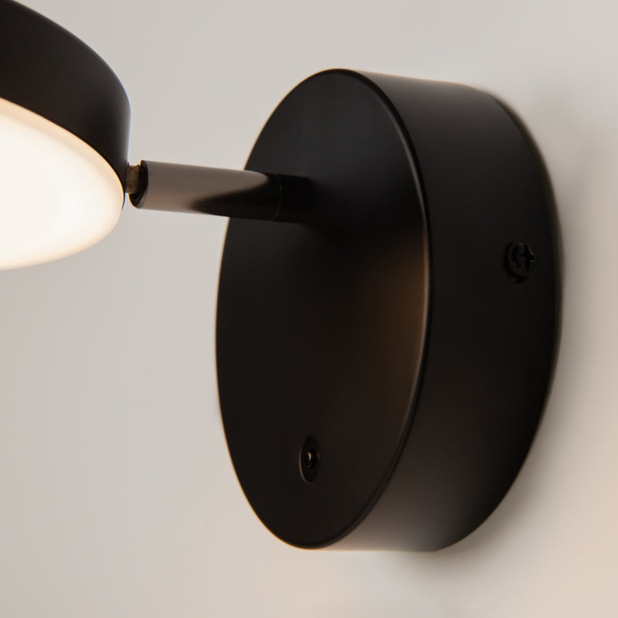 Détail de la base murale noire, bras orientable et interrupteur intégré en gros plan