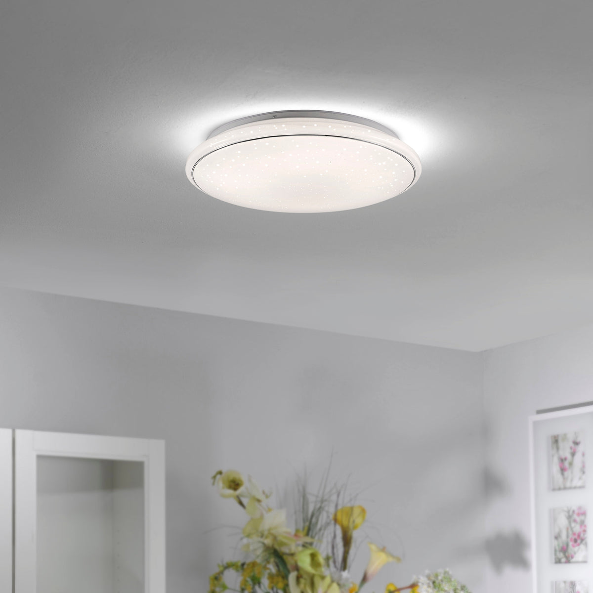 Plafonnier blanc allumé, fixé au plafond dans un intérieur contemporain