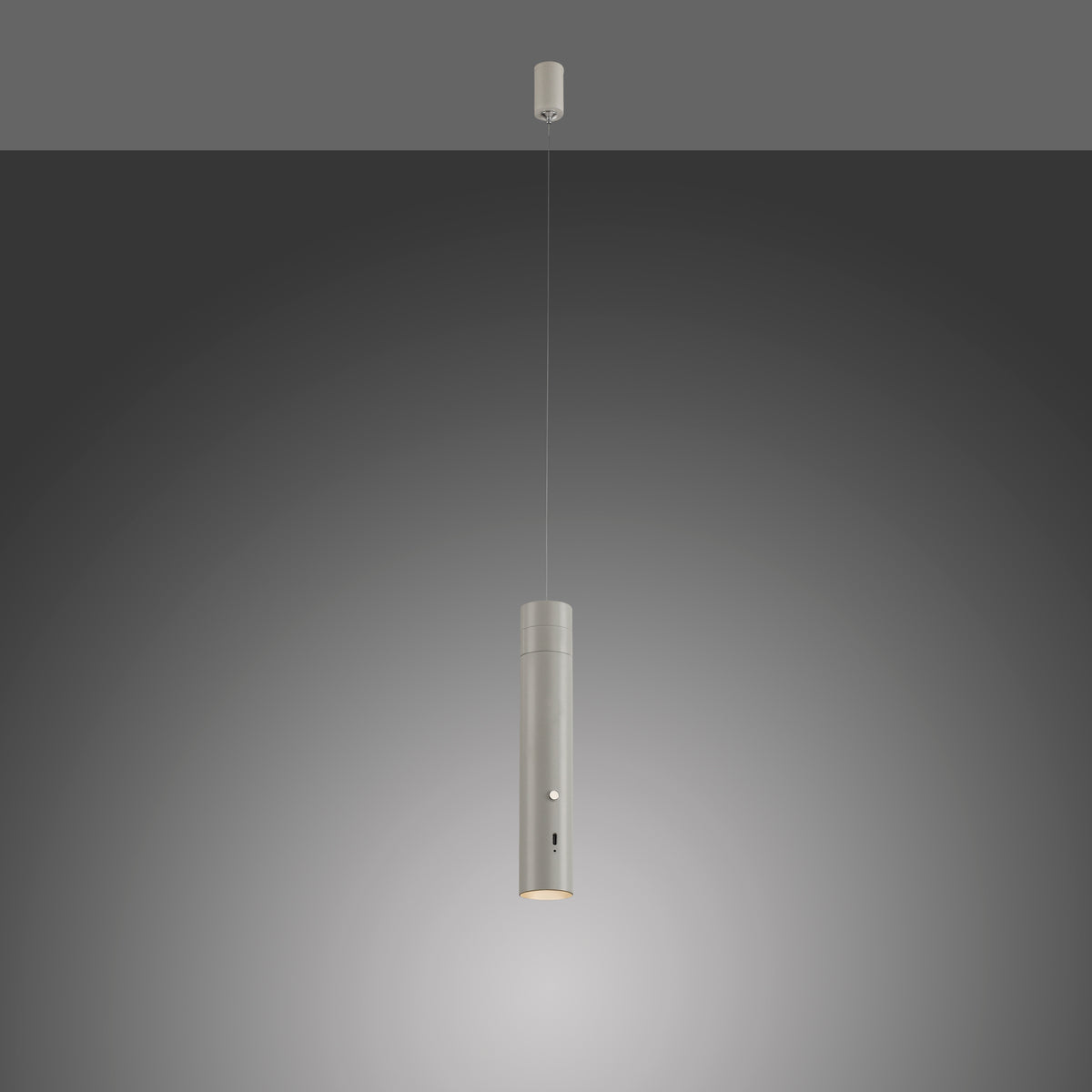 Luminaire suspendu gris éclairé sur fond dégradé sombre, lumière allumée.