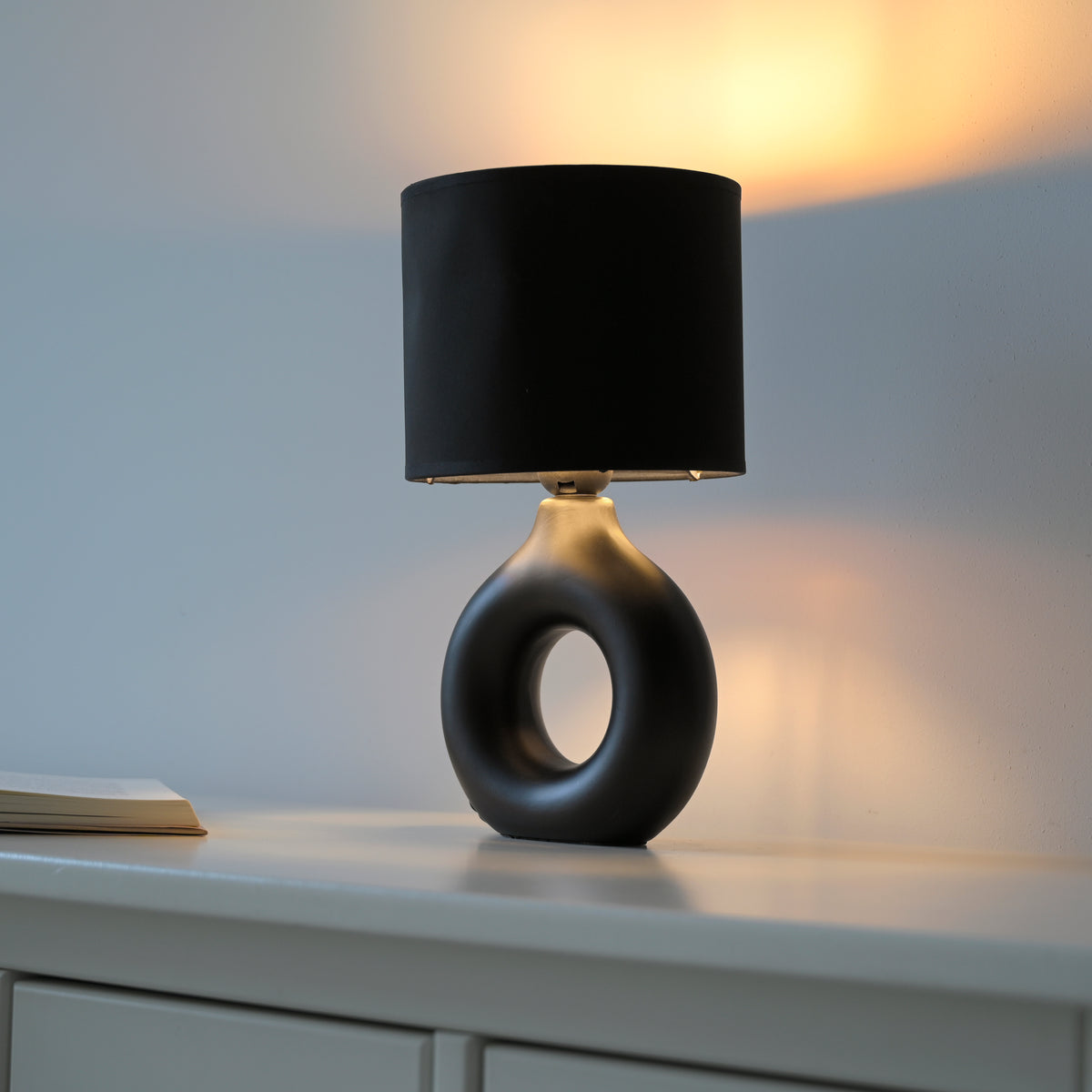 Mise en ambiance sur un meuble, lumière chaude diffusée sur le mur
