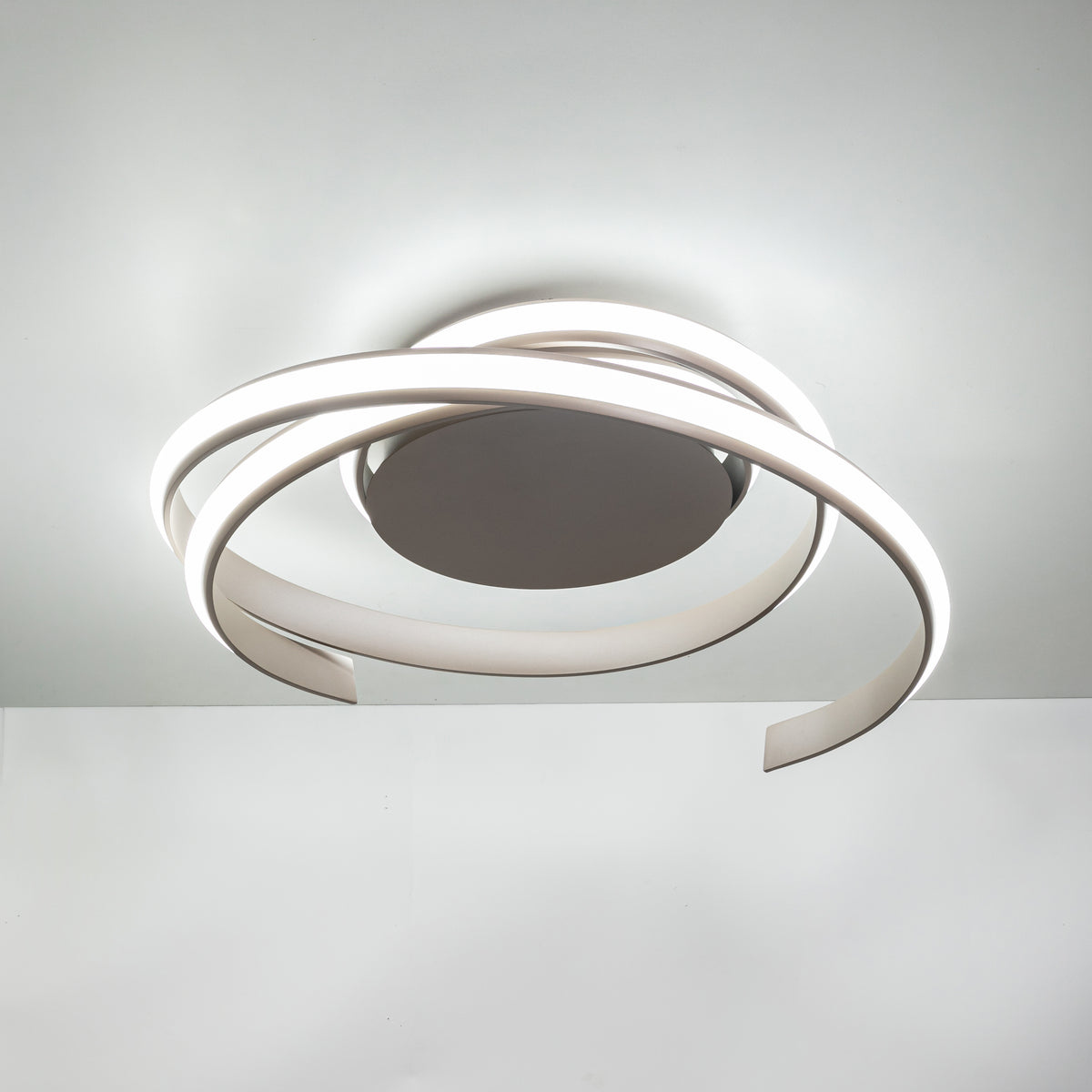 Plafonnier beige allumé en lumière froide, fixé au plafond, vue de face.