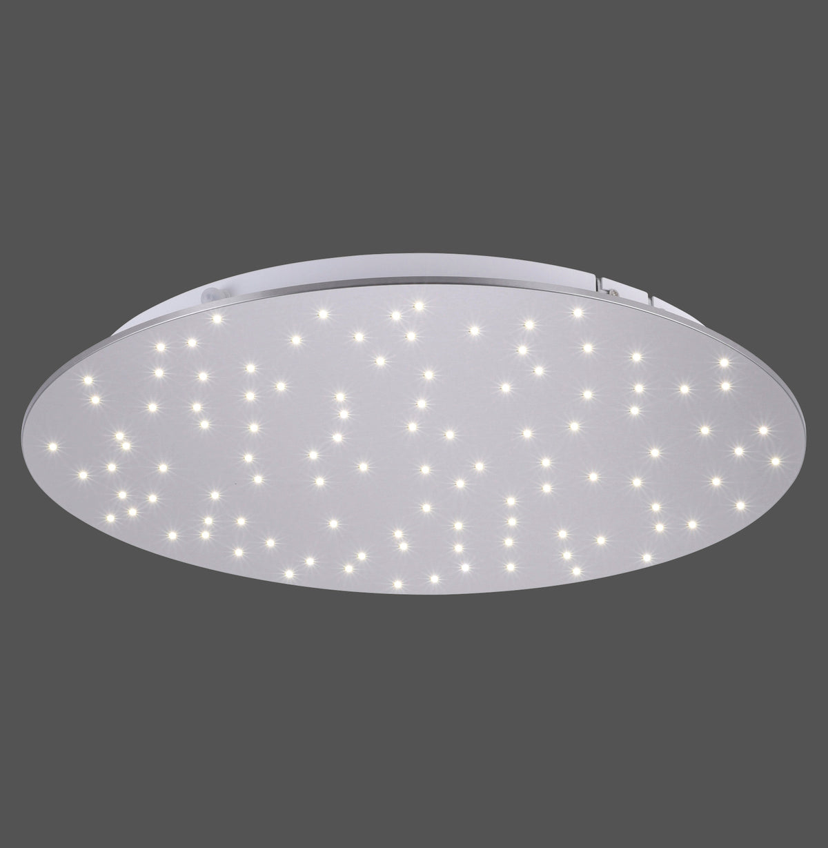 Vue de face du plafonnier rond éclairé, diffuseur blanc parsemé de petits points lumineux.
