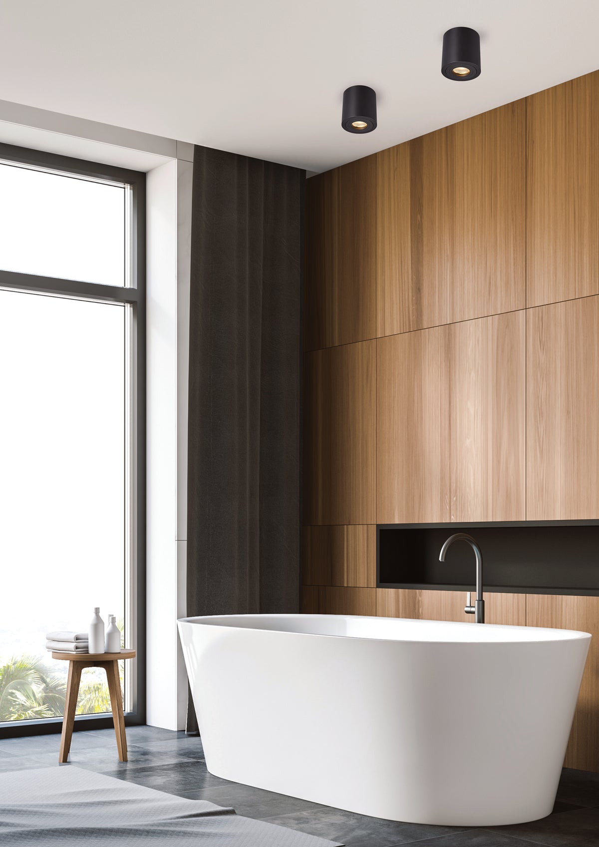 Salle de bain moderne avec baignoire îlot et spots noirs au plafond.