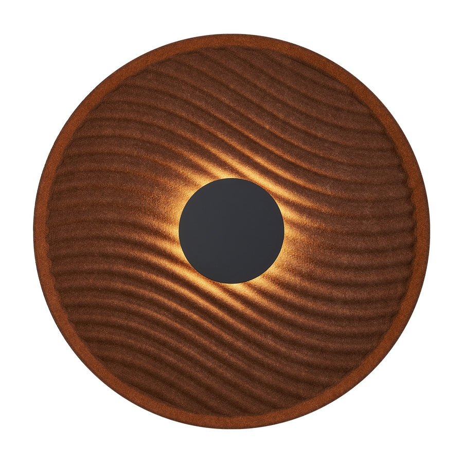 Applique murale ronde allumée, surface acoustique brune ondulée et disque central noir.
