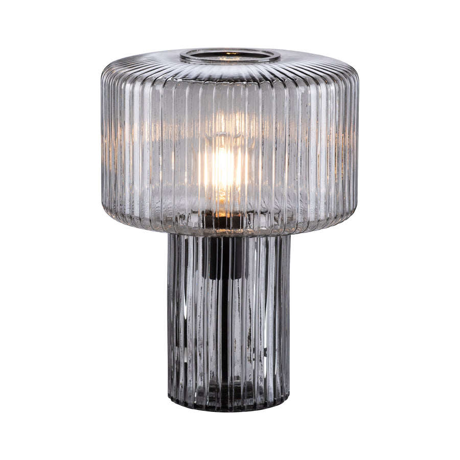 Vue détourée du luminaire en verre strié fumée, lumière chaude allumée sur fond blanc.