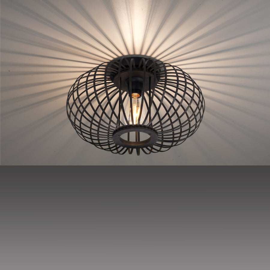 Plafonnier allumé projetant des ombres rayonnantes sur le plafond blanc.