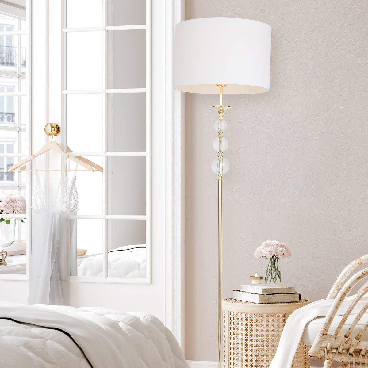 Lampadaire doré installé dans une chambre lumineuse, près d'un fauteuil en rotin.