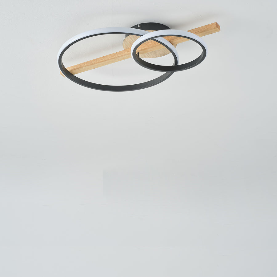 Luminaire éteint fixé au plafond, montrant les cercles noirs et la structure en bois