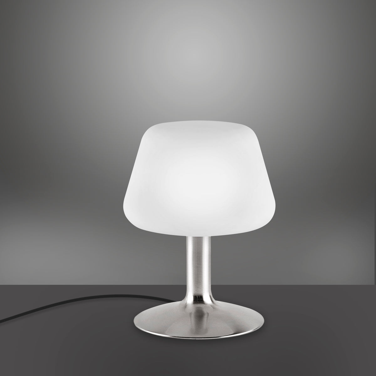 Lampe allumée diffusant une lumière chaude sur fond sombre, mettant en valeur le verre opalin