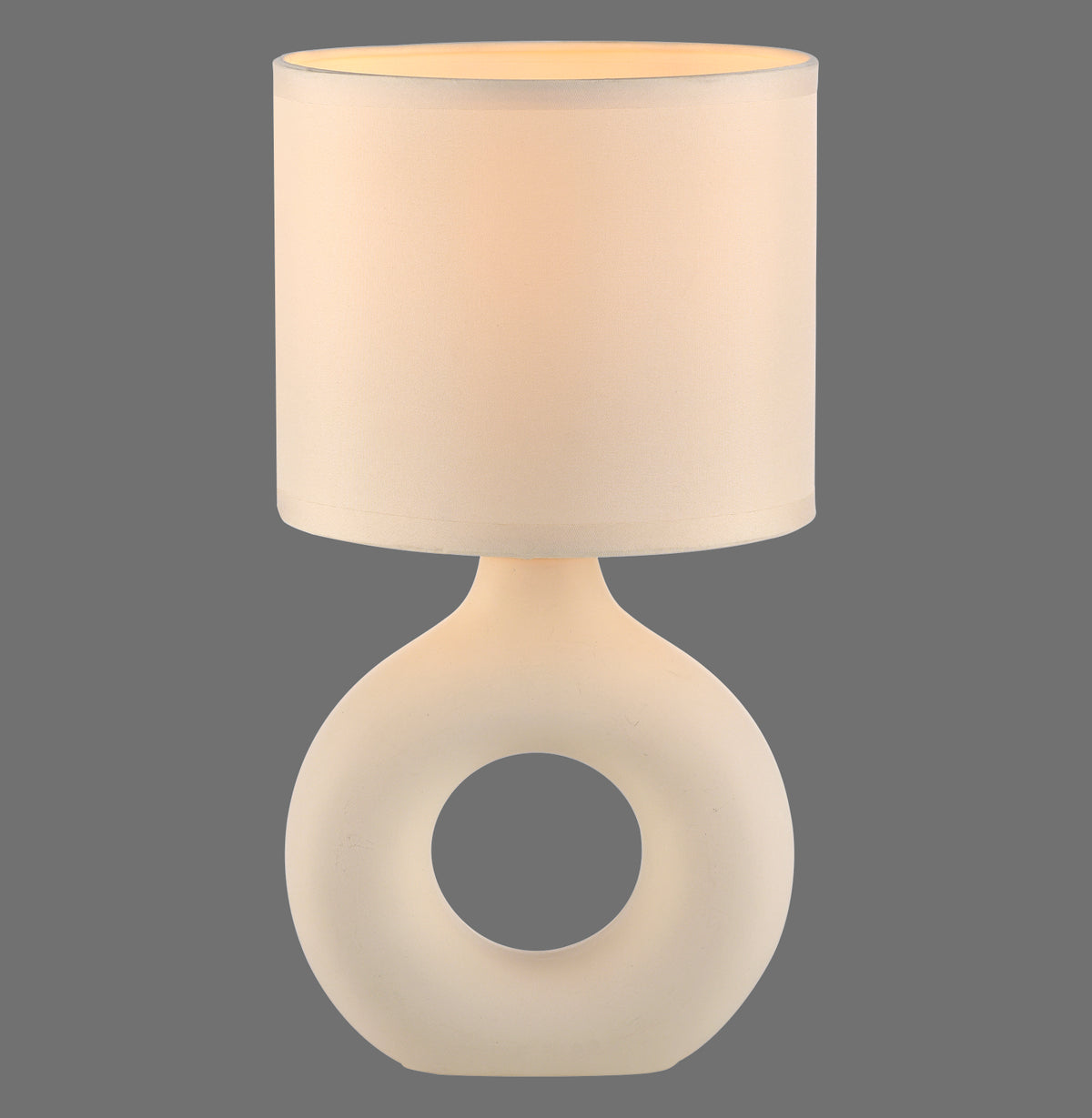 Lampe à poser beige de face sur fond gris, abat-jour cylindrique et base céramique ajourée.