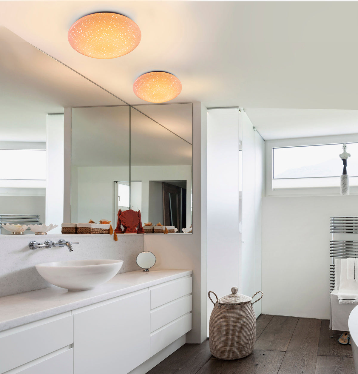 Mise en ambiance dans une salle de bain moderne, deux plafonniers étoilés au plafond.