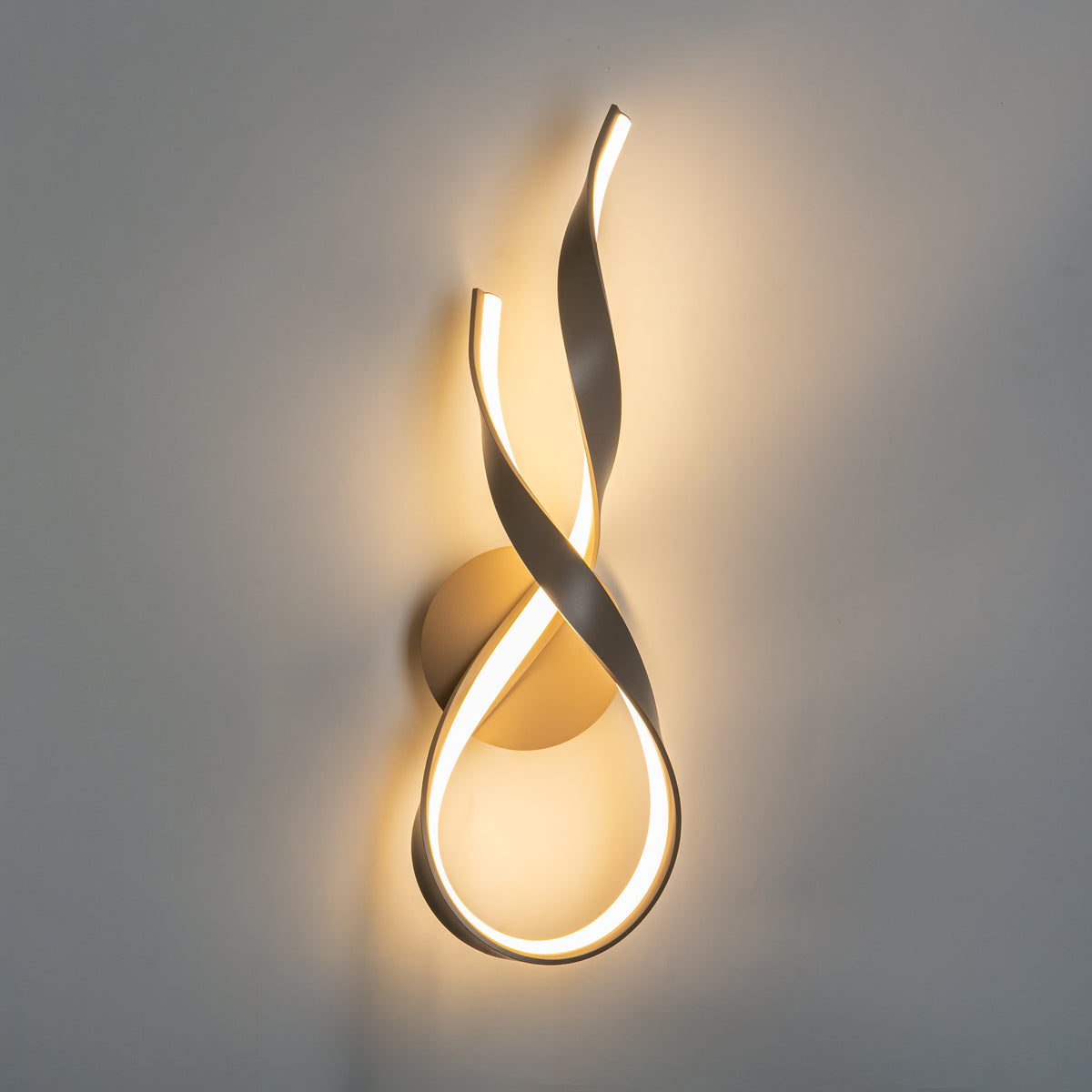 Même applique allumée sur mur gris, halo de lumière chaude diffusée autour du ruban