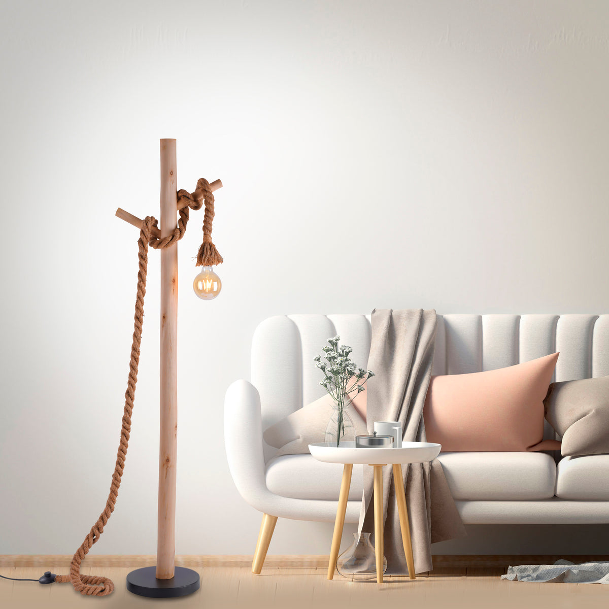 Mise en ambiance salon avec canapé blanc, lampadaire en bois et corde à gauche.