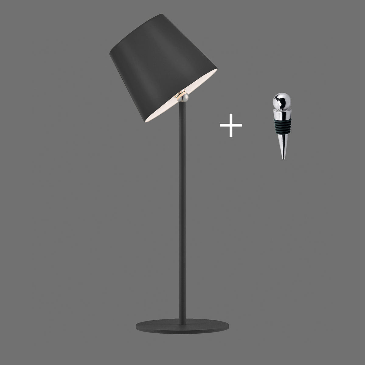 Lampe à poser noire inclinée avec bouchon de bouteille métallique et signe plus sur fond gris.