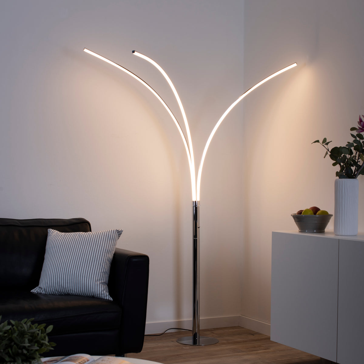 Lampadaire allumé dans un coin sombre, éclairant les murs et le mobilier.