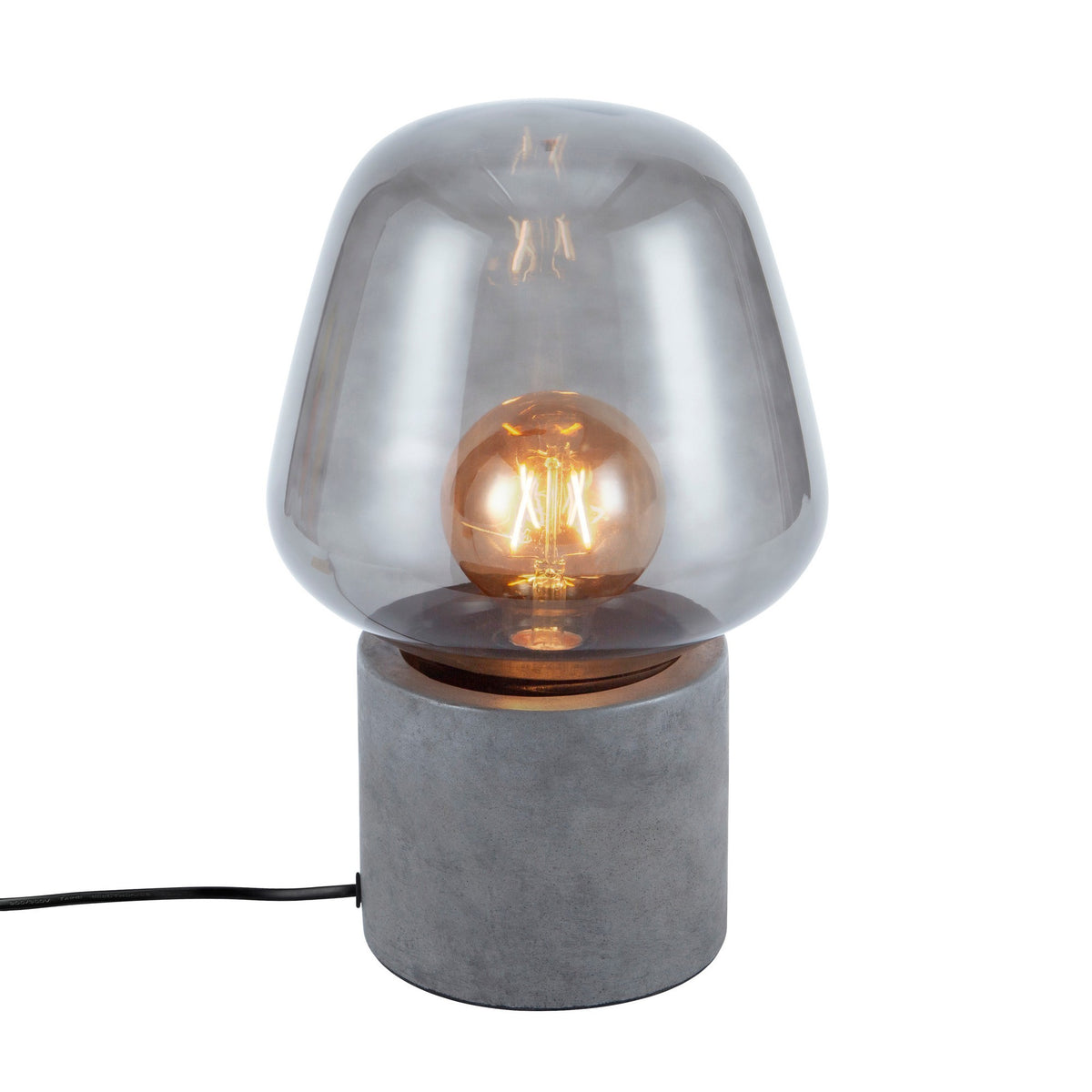 Lampe à poser avec base cylindrique en béton et abat-jour en verre fumé, ampoule allumée.