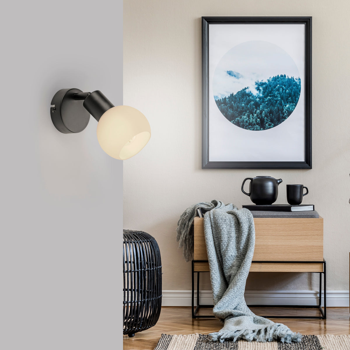 Mise en ambiance de l'applique murale noire dans un intérieur contemporain avec cadre et meuble.