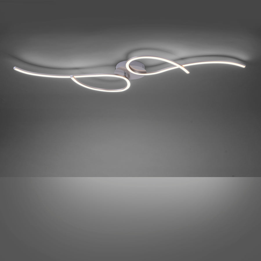 Luminaire allumé dans une pièce sombre, halos lumineux projetés au plafond par le ruban LED.