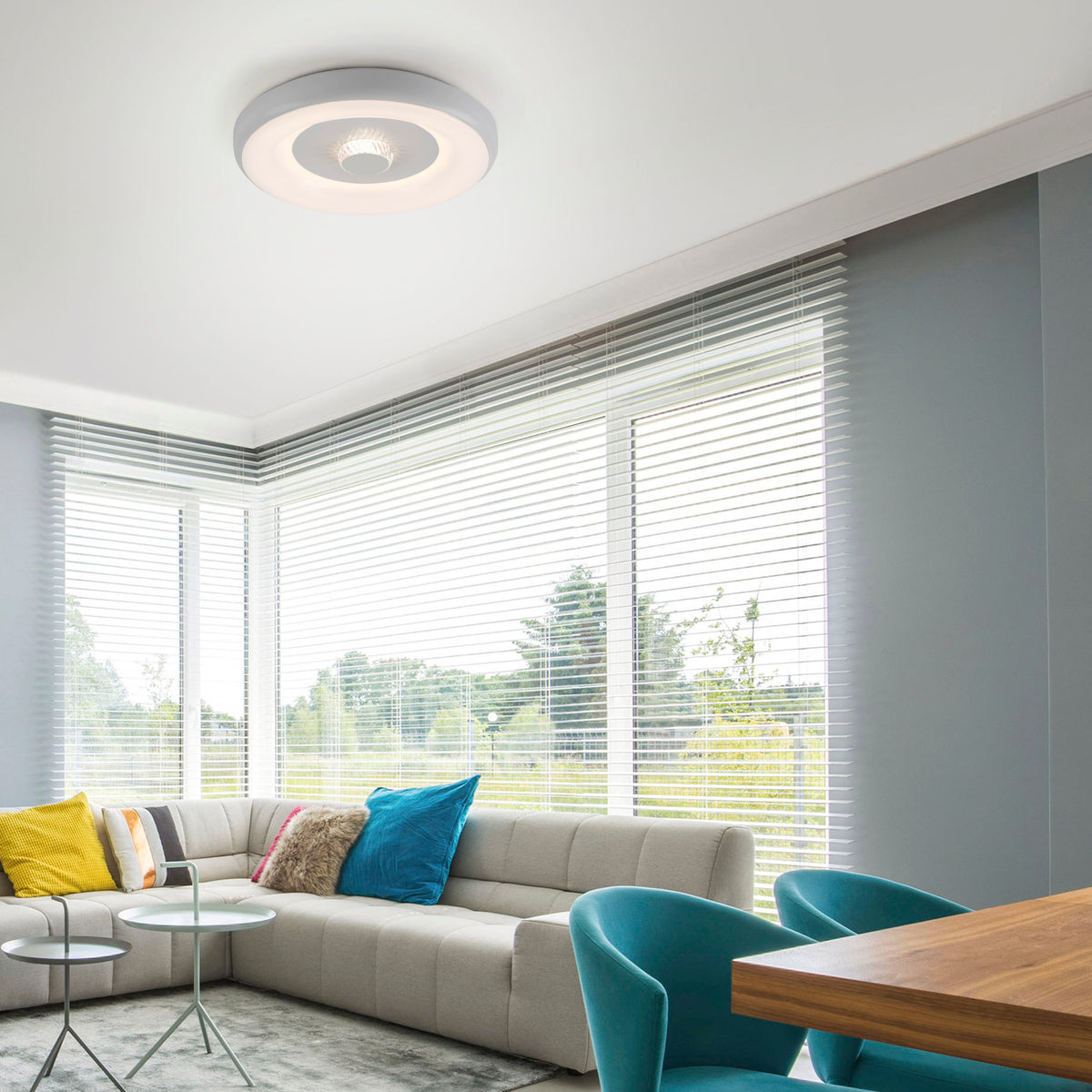 Mise en ambiance dans un salon moderne, plafonnier allumé en blanc au plafond.