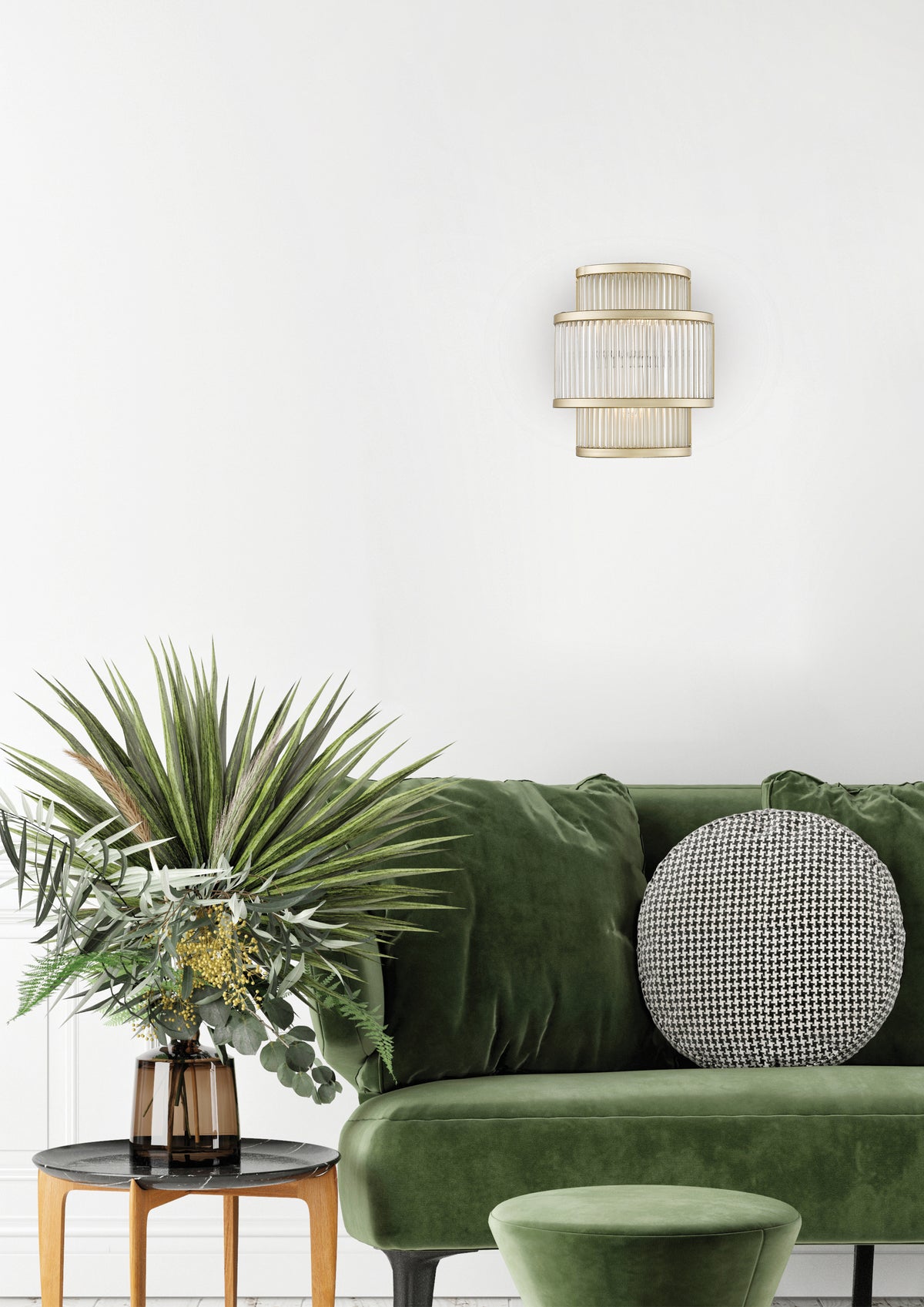 Applique murale dorée fixée sur un mur blanc au-dessus d'un canapé vert