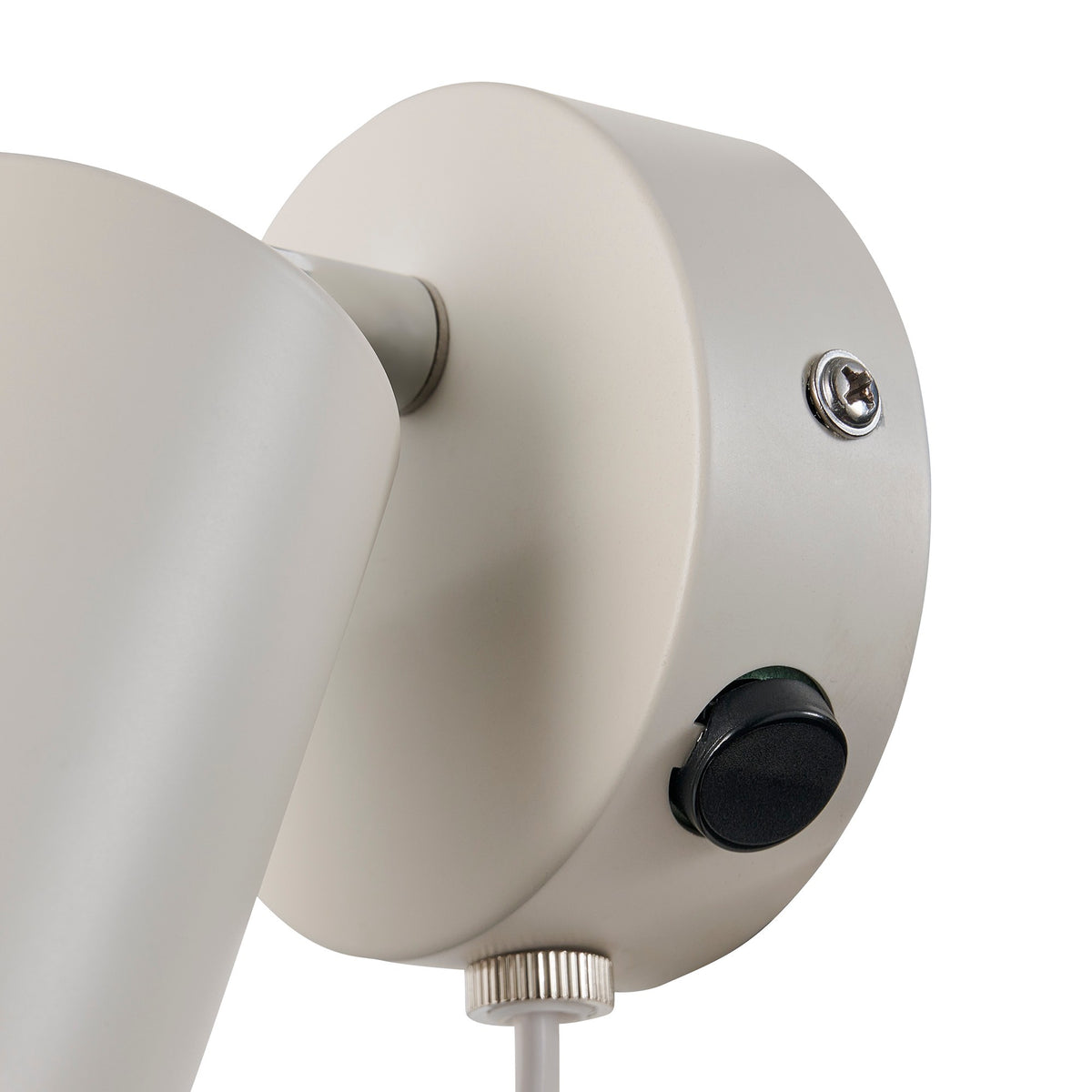 Gros plan sur la base murale : vis, interrupteur noir et finition mate.