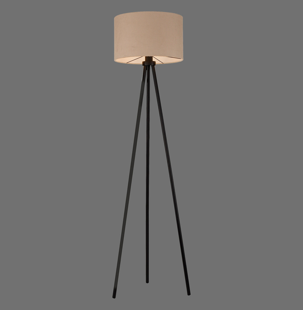 Lampadaire trépied noir allumé, abat-jour cylindrique beige sur fond gris uni
