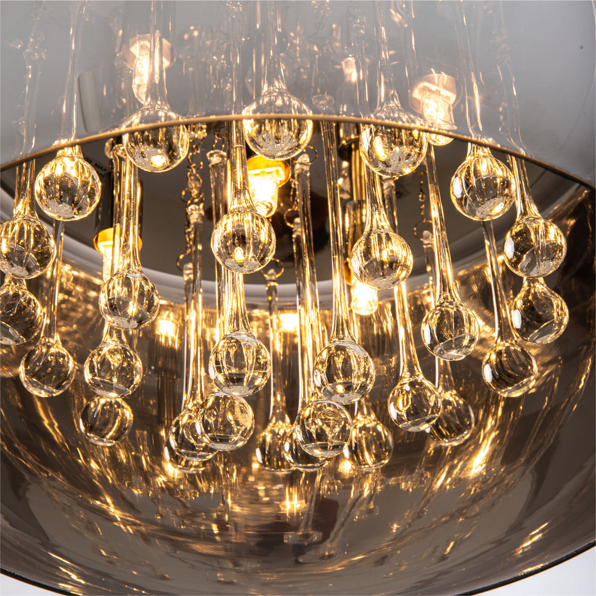 Gros plan sur les gouttes de cristal suspendues et les ampoules dorées à l'intérieur