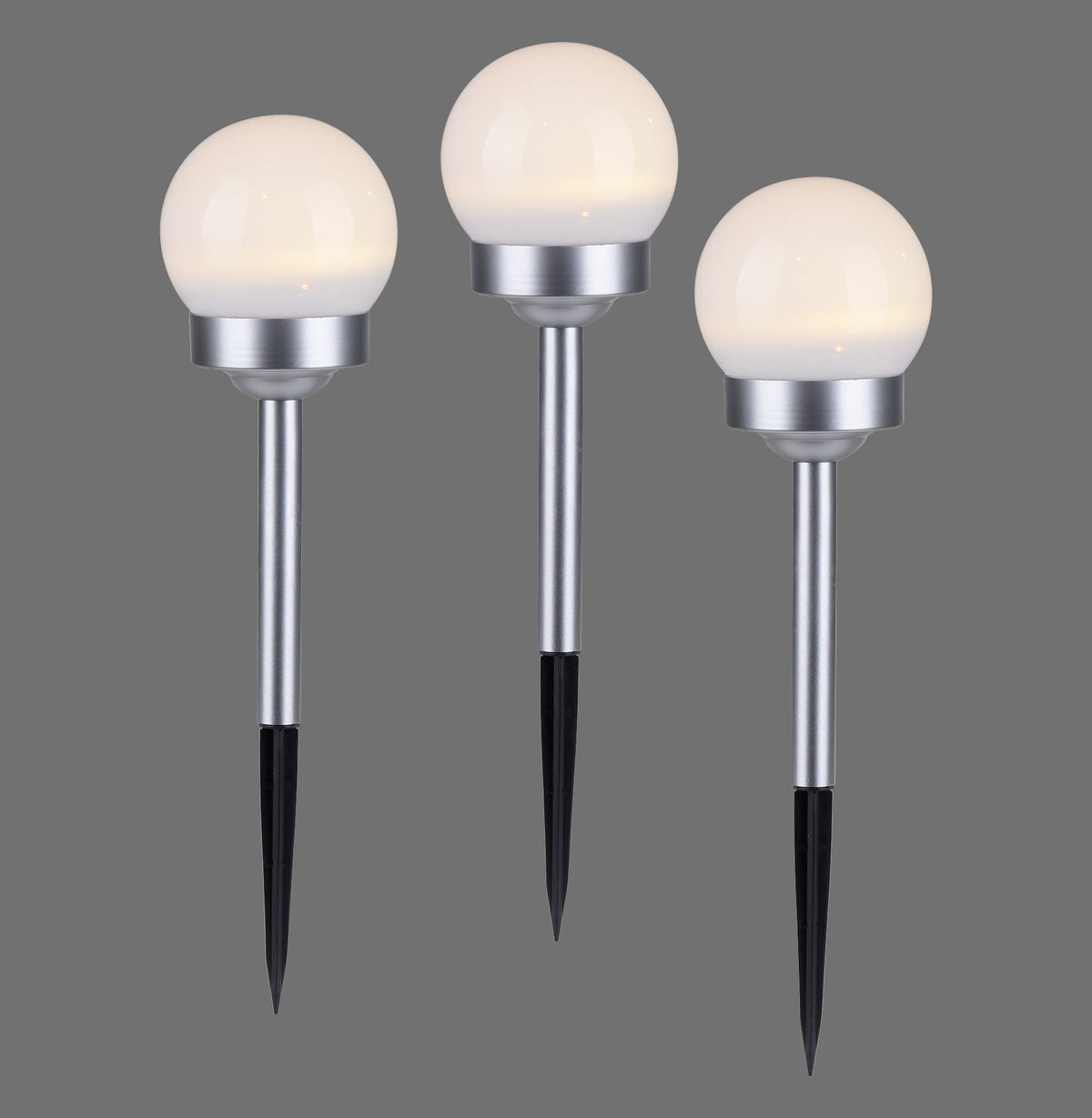 Trois piquets lumineux solaires à globe blanc et tige acier, vus de face sur fond gris