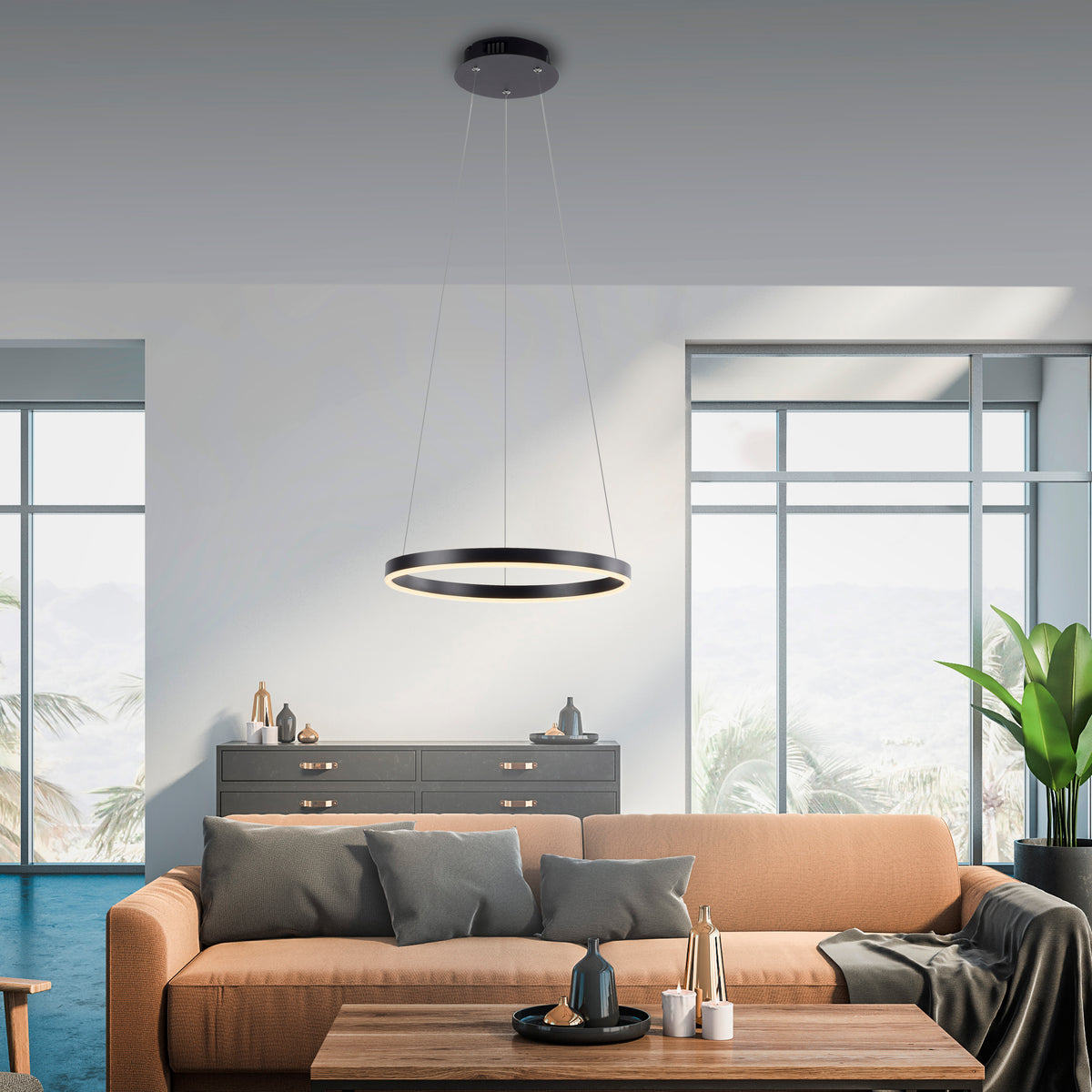Mise en ambiance dans un salon moderne, suspension allumée au-dessus d'un canapé et d'une commode.