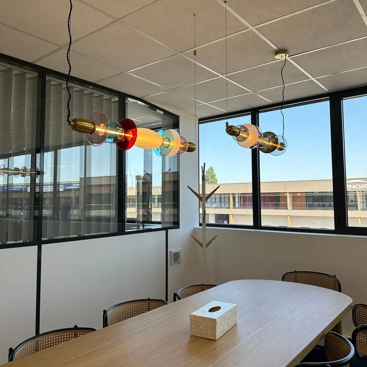 Vue d'ensemble de deux suspensions horizontales multicolores suspendues au-dessus d'une table en bois