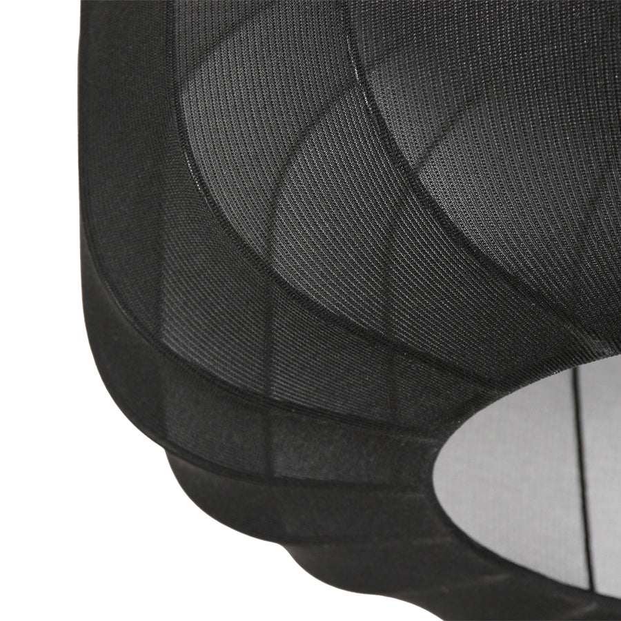 Gros plan sur la maille tissée noire et la couture du bord