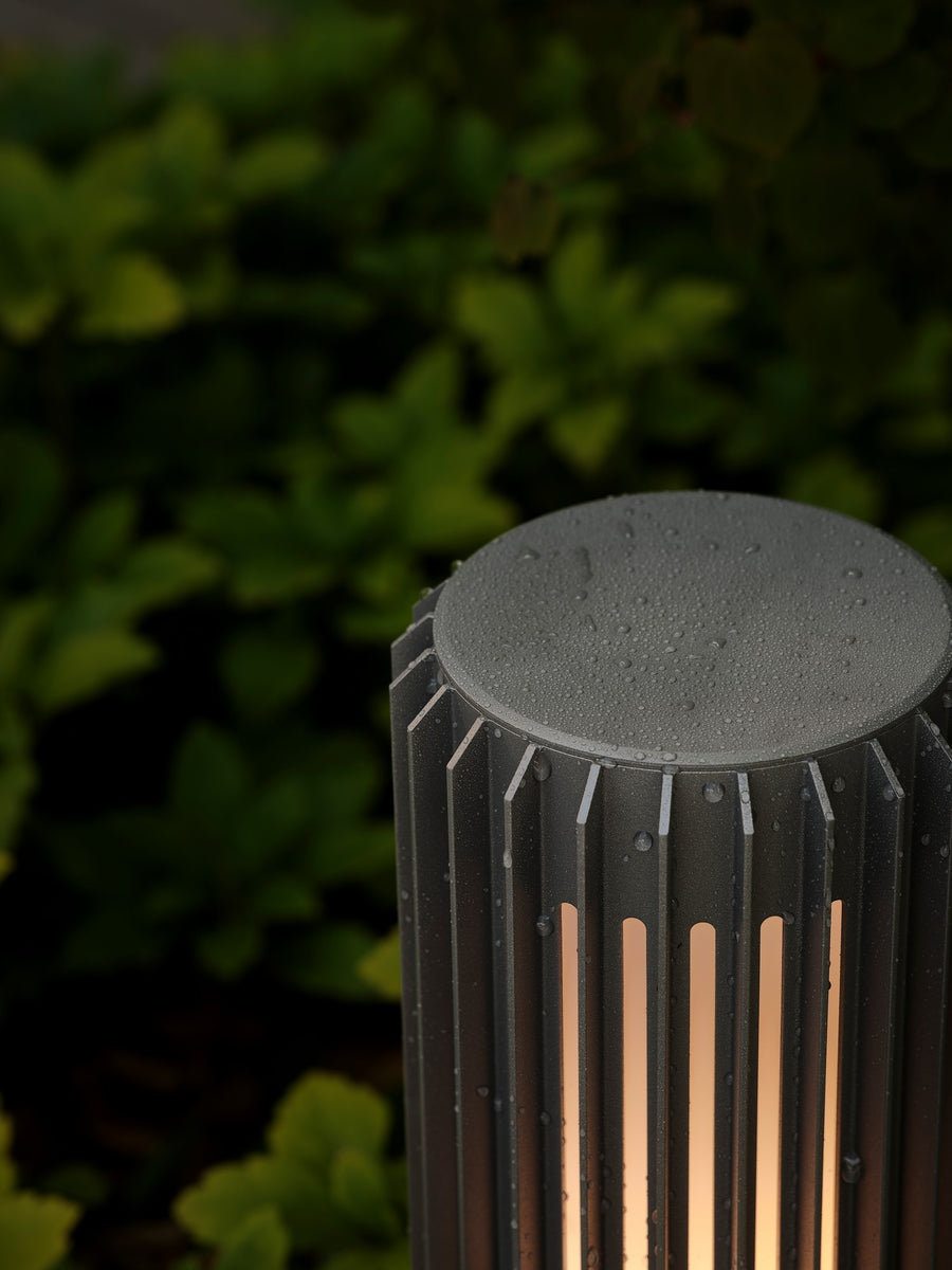 Détail rapproché du chapeau de la borne couvert de gouttes de pluie