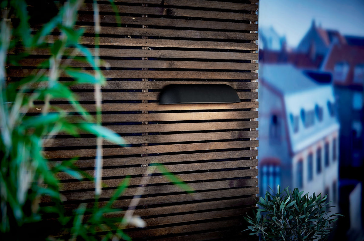 Mise en ambiance nocturne sur façade en lattes de bois, terrasse urbaine