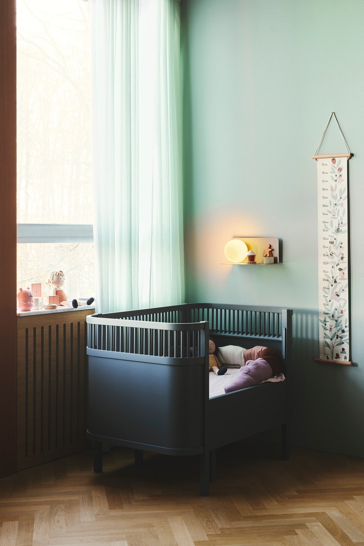 Mise en ambiance dans une chambre d enfant près d un lit bébé bleu.