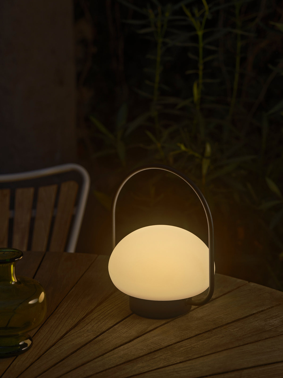 Mise en ambiance nocturne sur une table en bois, lampe allumée.