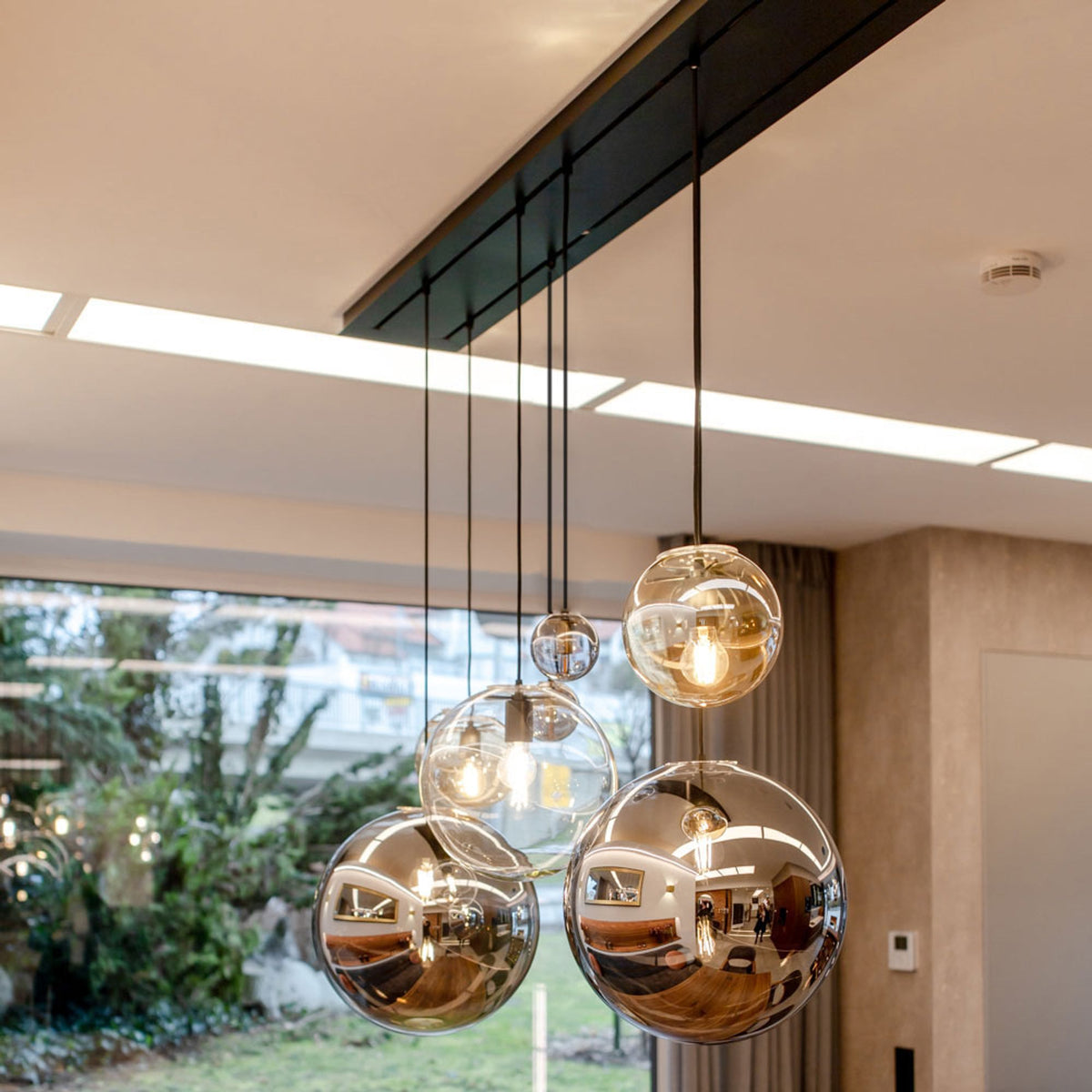 Détail de globes verre clair et verre miroir fumé sur rail noir au plafond