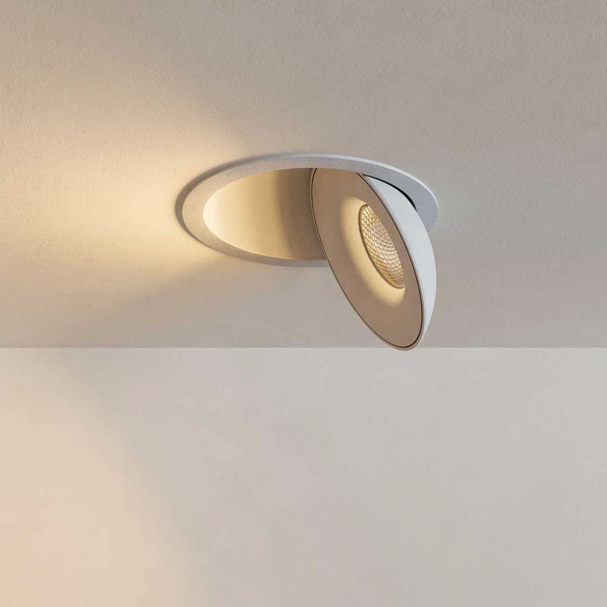 Spot encastrable blanc incliné, vue de dessous montrant lentille et réflecteur