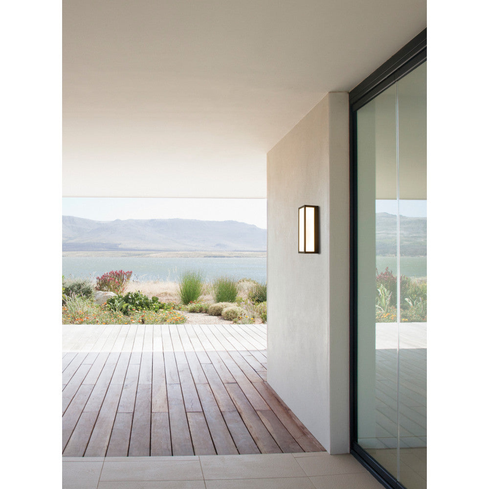 Applique murale rectangulaire allumée sur une terrasse face au lac et aux montagnes.
